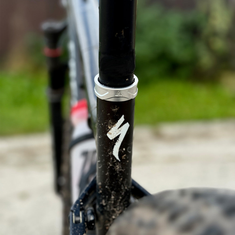 Srebrna obejma sztycy ALUGEAR zamontowana na rurze podsiodłowej czarnej ramy MTB, ujęcie lifestylowe