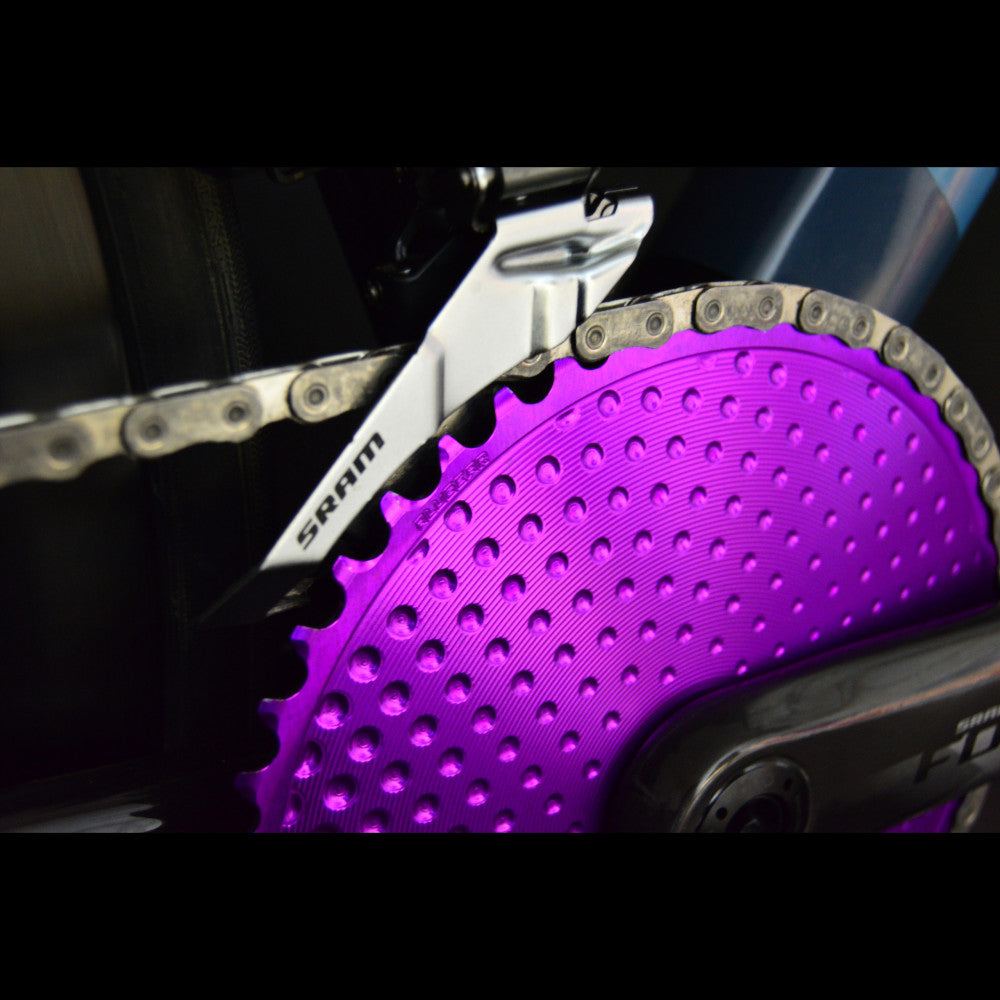 Purple ALUGEAR round road chainring on SRAM Force crank, close-up detail showing chain engagement and dotted surface