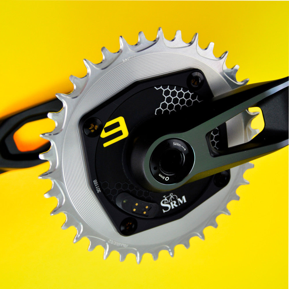 Silver ALUGEAR round AERO chainring on SRM power meter crank against yellow background