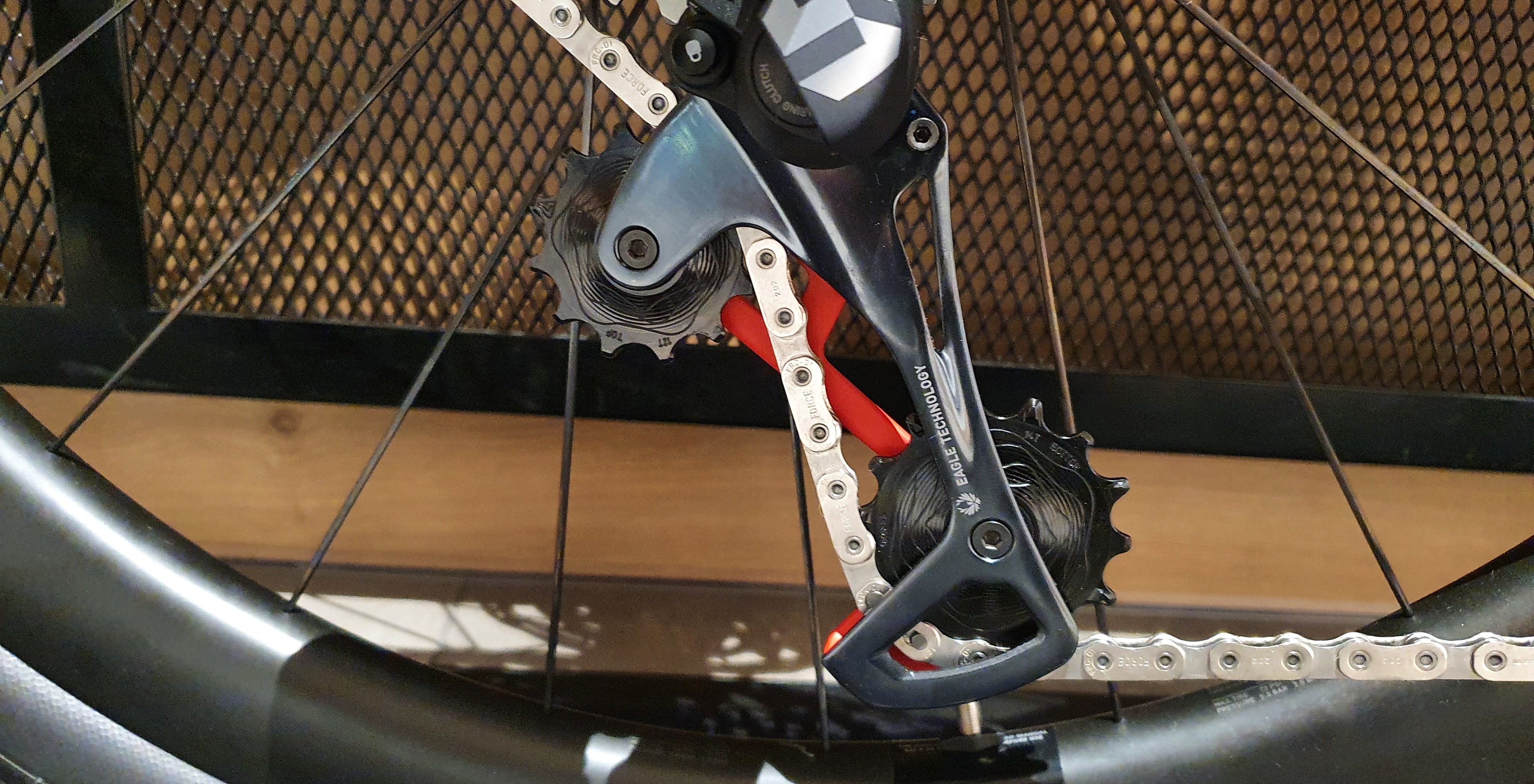 SRAM rear derailleur with red anodized ALUGEAR jockey wheel installed, on-bike close-up