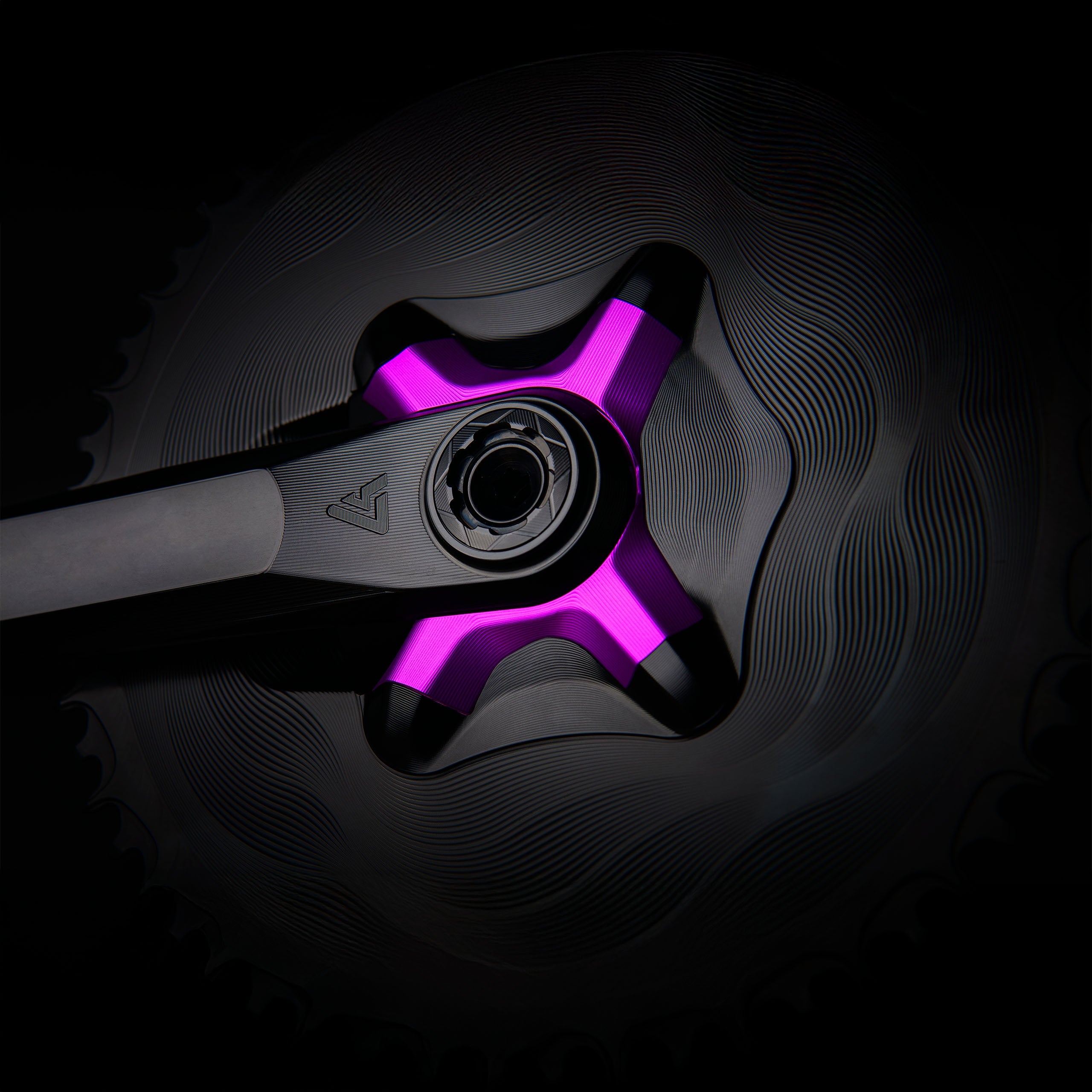 Purple anodized ALUGEAR 4-arm spider close-up on crank spindle, wave-machined AERO chainring background