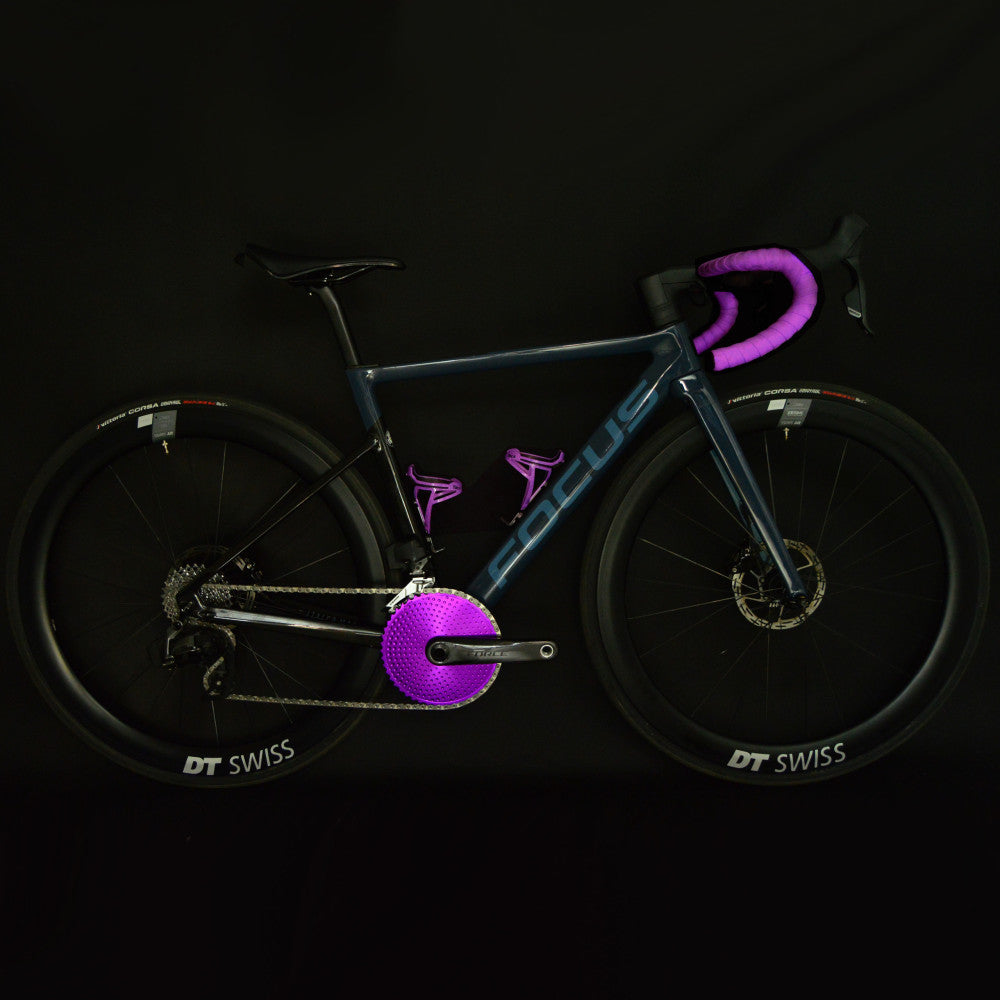 Purple ALUGEAR round road chainring on SRAM Force crank fitted on a dark blue Focus road bike, full studio shot